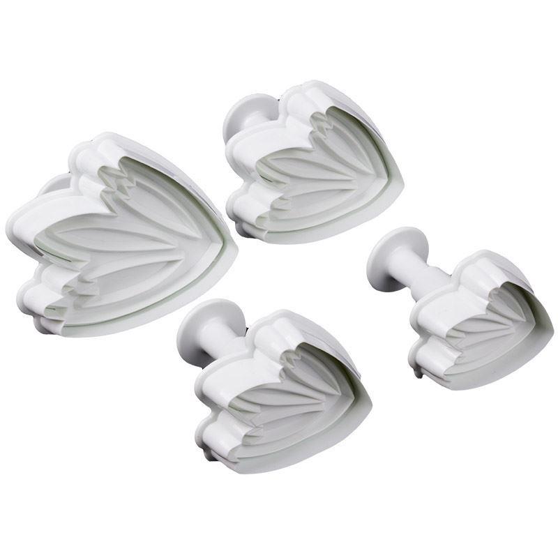 Set of four white floral-shaped fondant plunger cutters on a white background